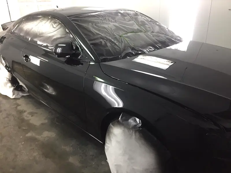 Restored Black Audi with a smooth mirror finish and high-gloss paint after dent repair