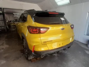 The rear of the Gold-Lime Chevrolet, seamlessly repaired, color-matched, and repainted with a flawless gloss finish following the severe collision.