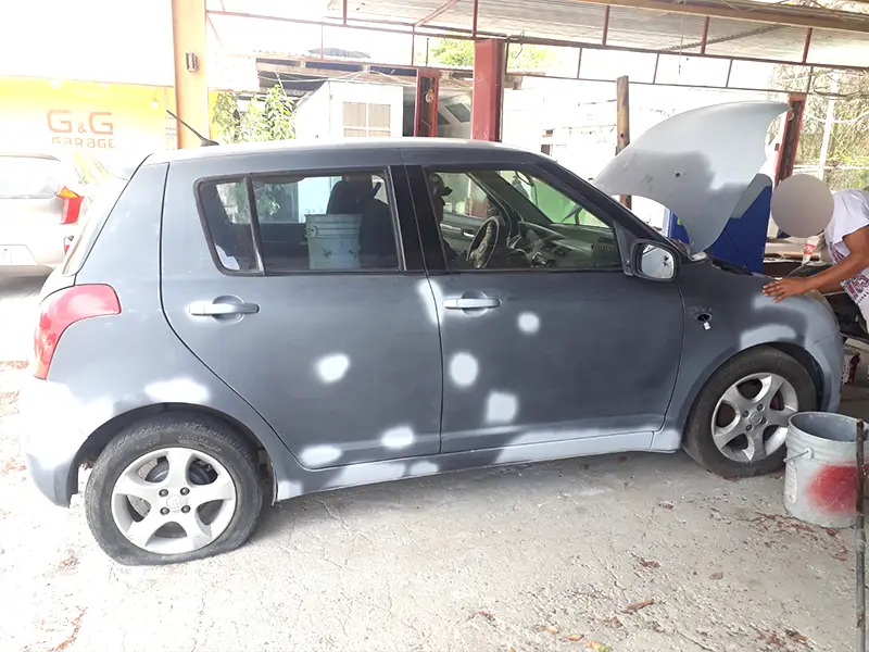 Gray Suzuki Swift with small body dents repair before repaint at Garage G&G.